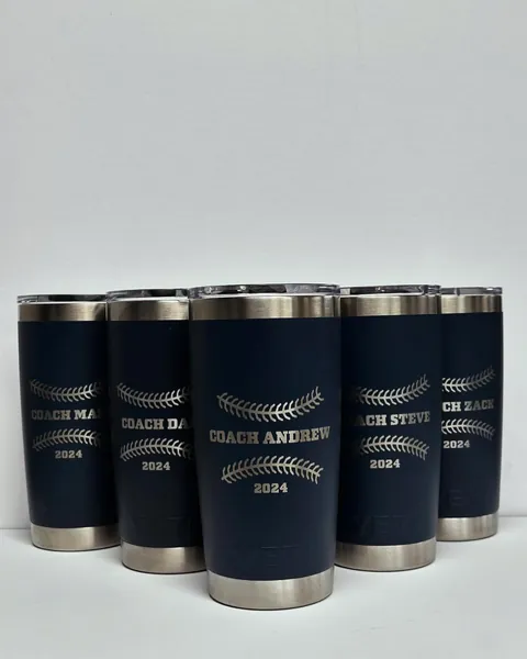 Navy tumblers, each engraved with a different coach’s name.